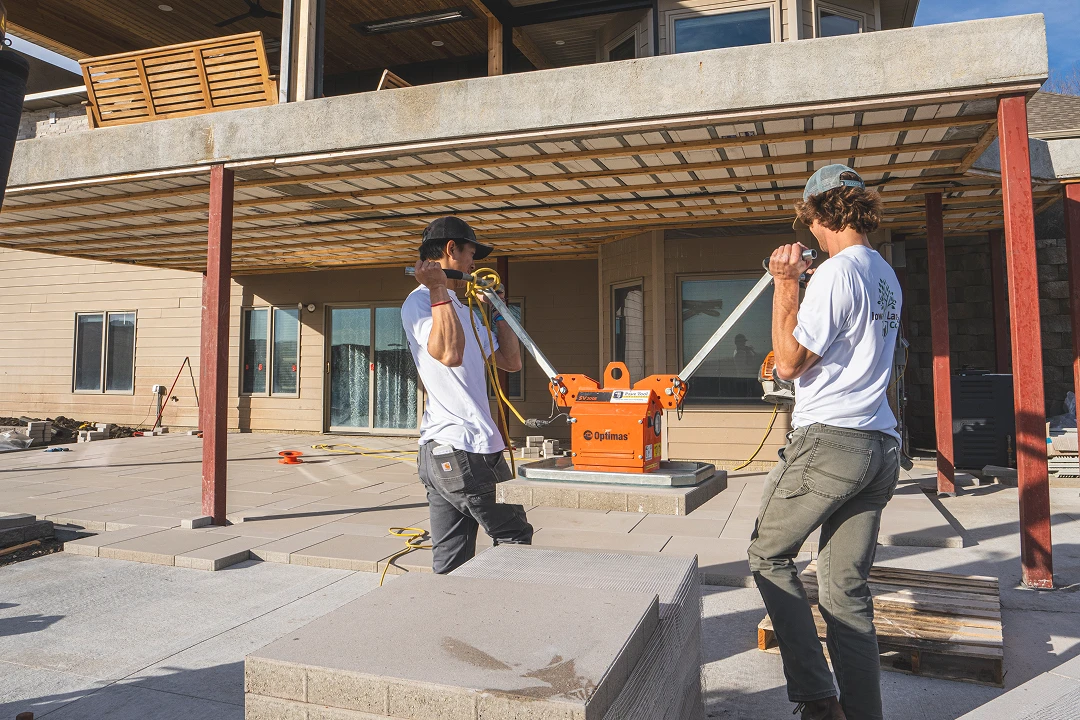 Workers installing concrete slabs with machinery.