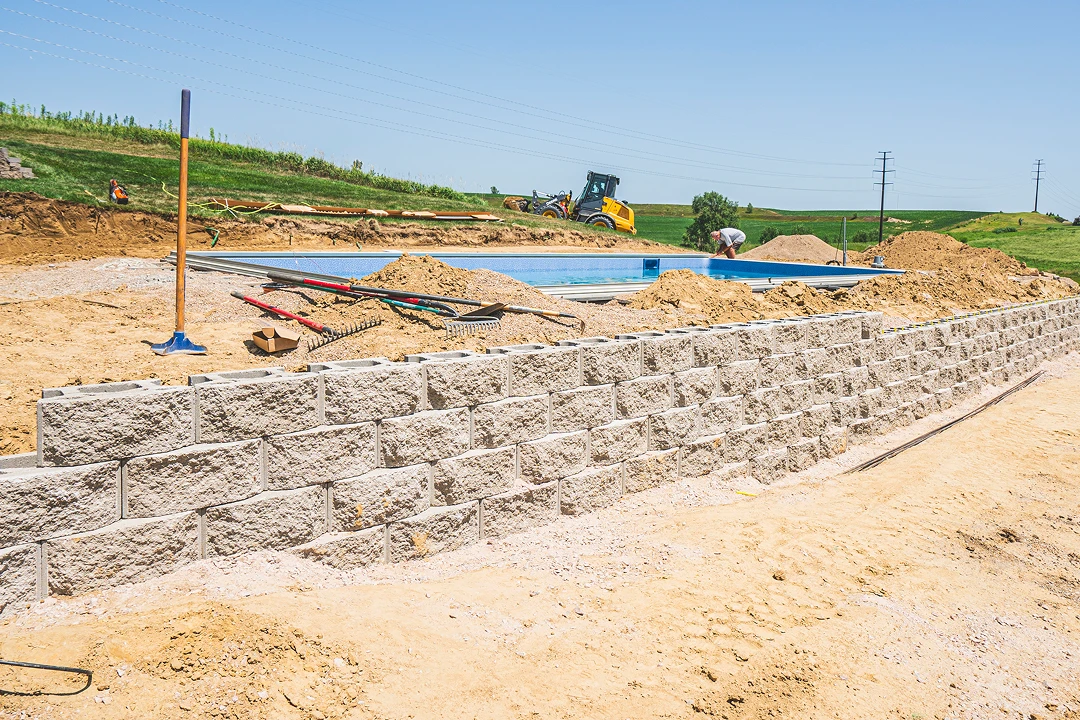 Construction site with retaining wall and tools.