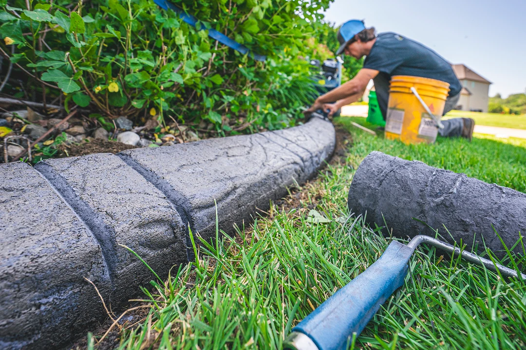 Person installing concrete garden edging.