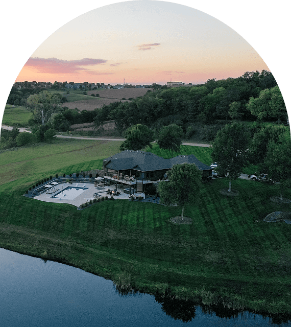 Aerial view of house by a pond.