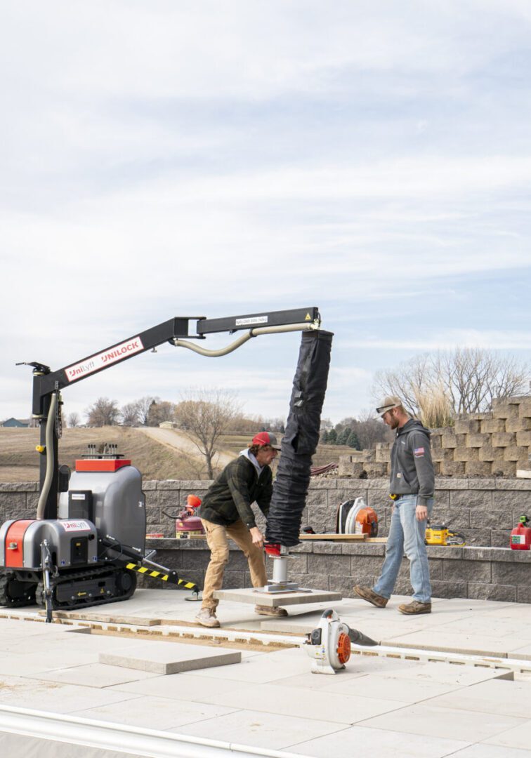 Workers installing a wall insulation system on a construction site.