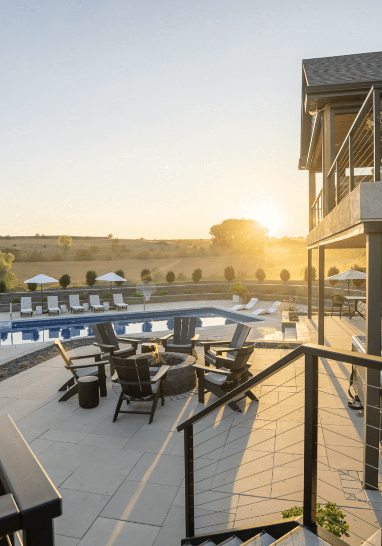 Sunset view over a modern outdoor pool area with seating and umbrellas.